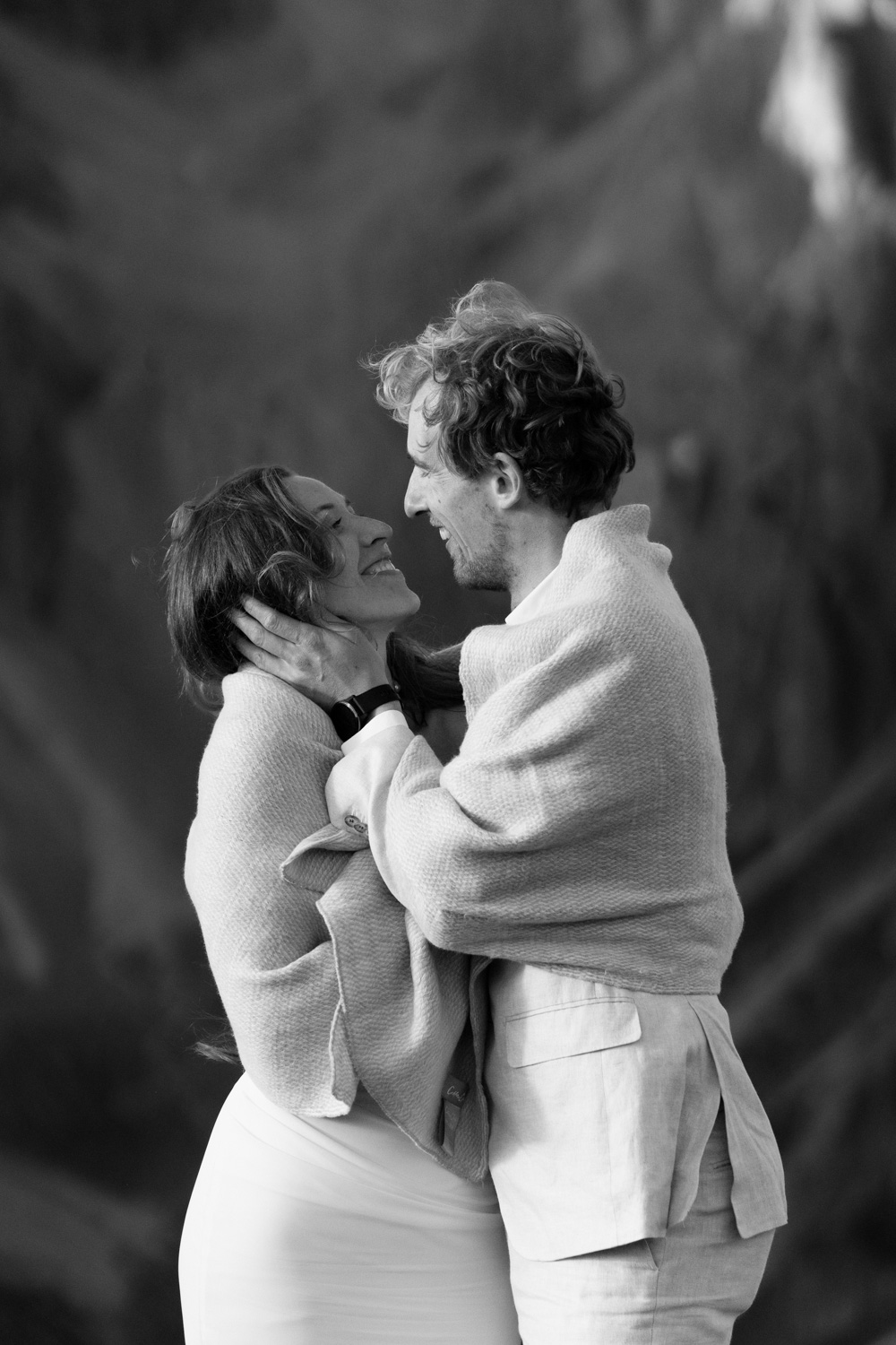 A black and white photo of a couple facing each other and embracing during their Italian Dolomites elopement.