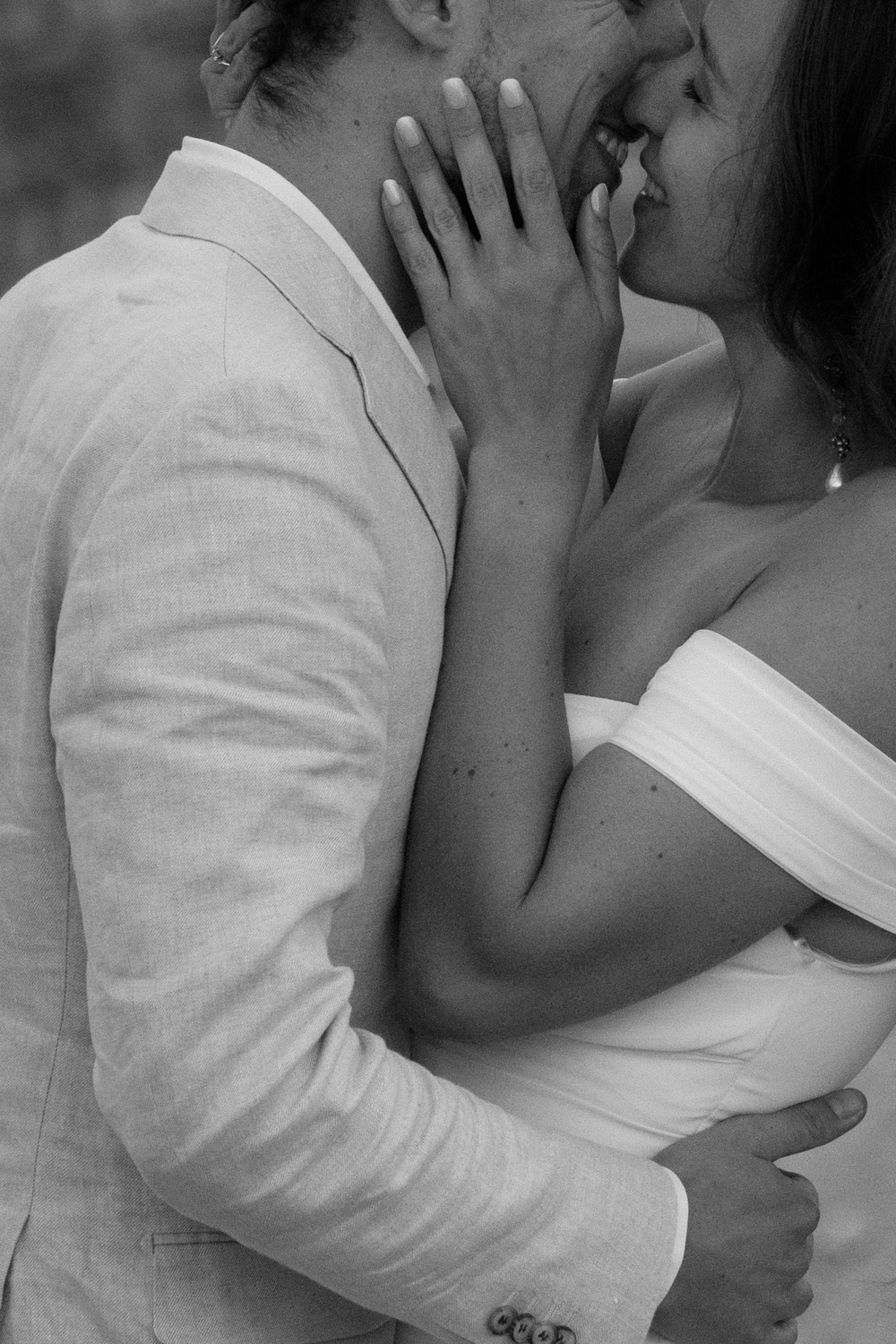 A black and white close up photo of a couple in wedding attire, kissing, during their Italian Dolomites elopement. 