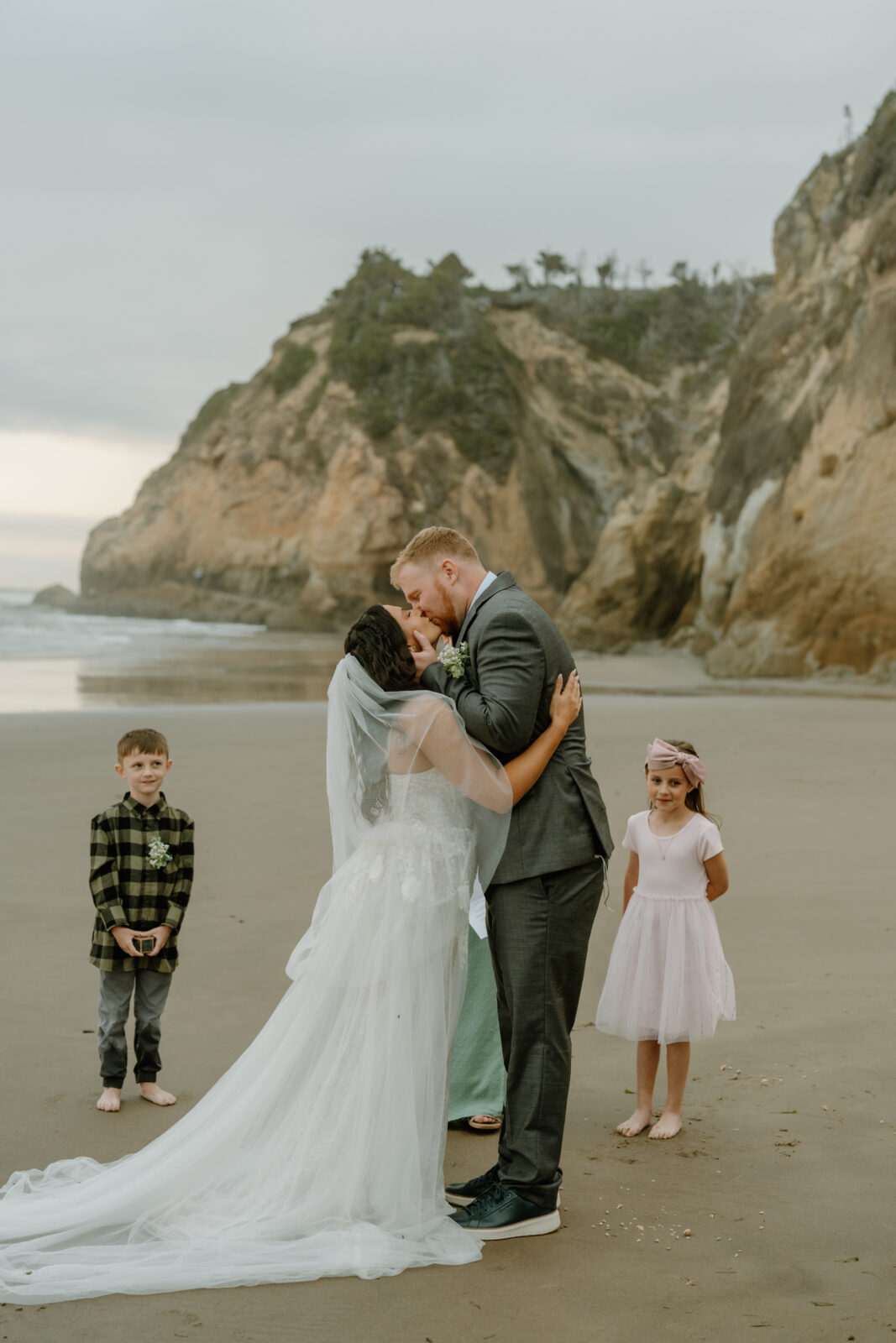 Micro-wedding photos at Hug Point on the Oregon Coast. Featuring sandy beaches and tall, imposing rock formations