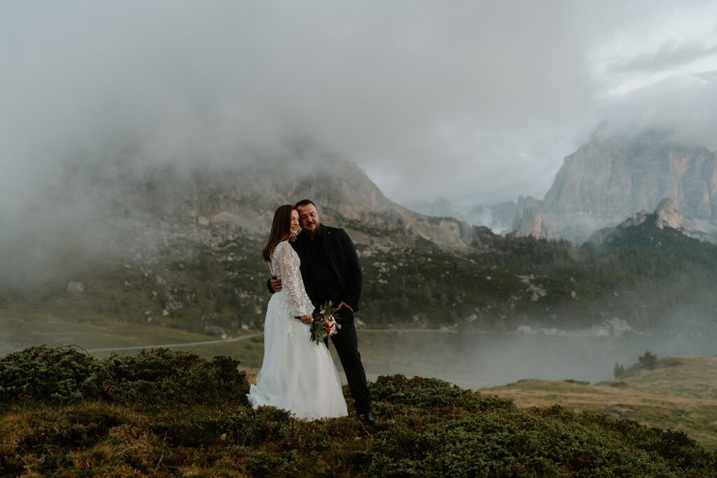 A couple poses for their elopement photos in the Italian Dolomites near Passo di Giau.