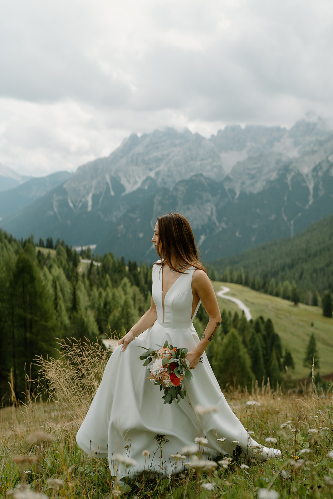 A couple poses in an alpine meadow for their Dolomites elopement photos.