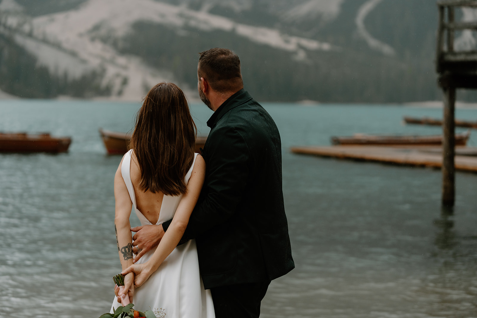 A couple poses for photos during their elopement at Lago di Braies in the Italian Dolomites.