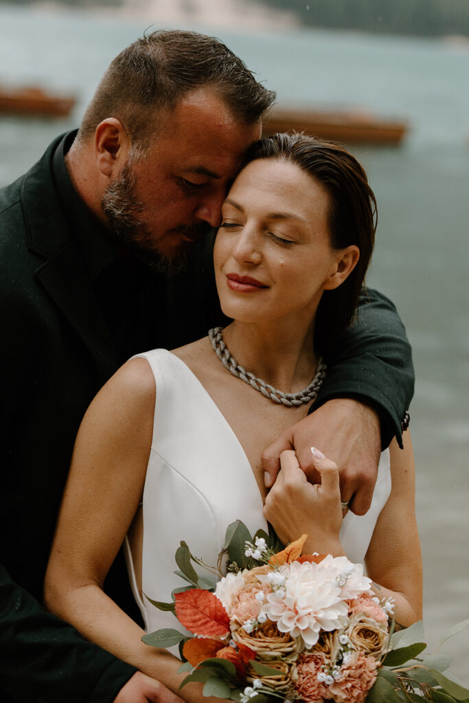 A couple poses for photos during their elopement at Lago di Braies in the Italian Dolomites.
