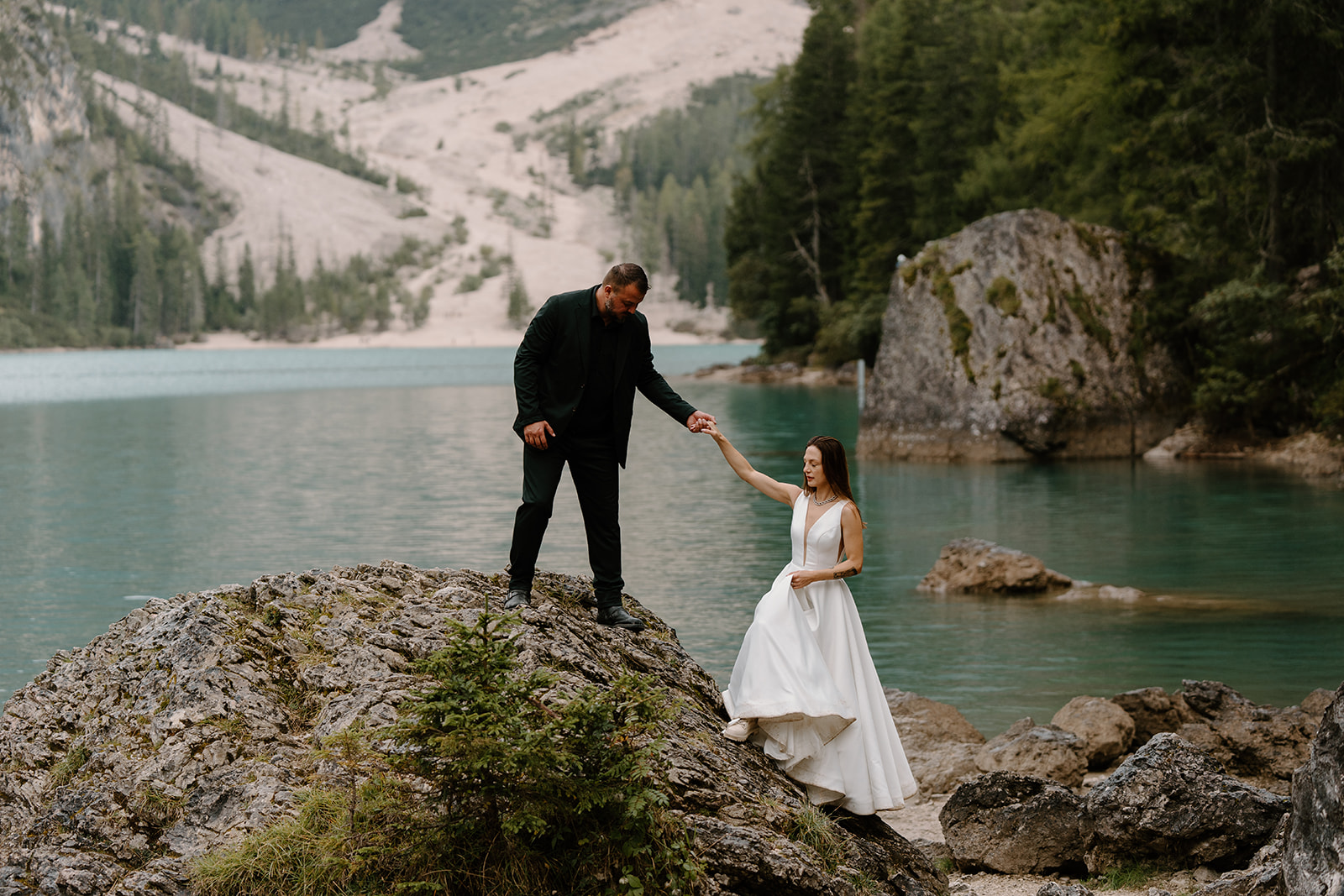 A couple poses for photos during their elopement at Lago di Braies in the Italian Dolomites.