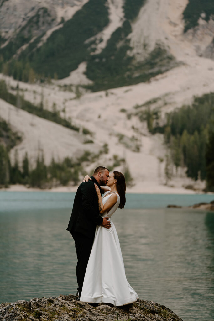 A couple poses for photos during their elopement at Lago di Braies in the Italian Dolomites.