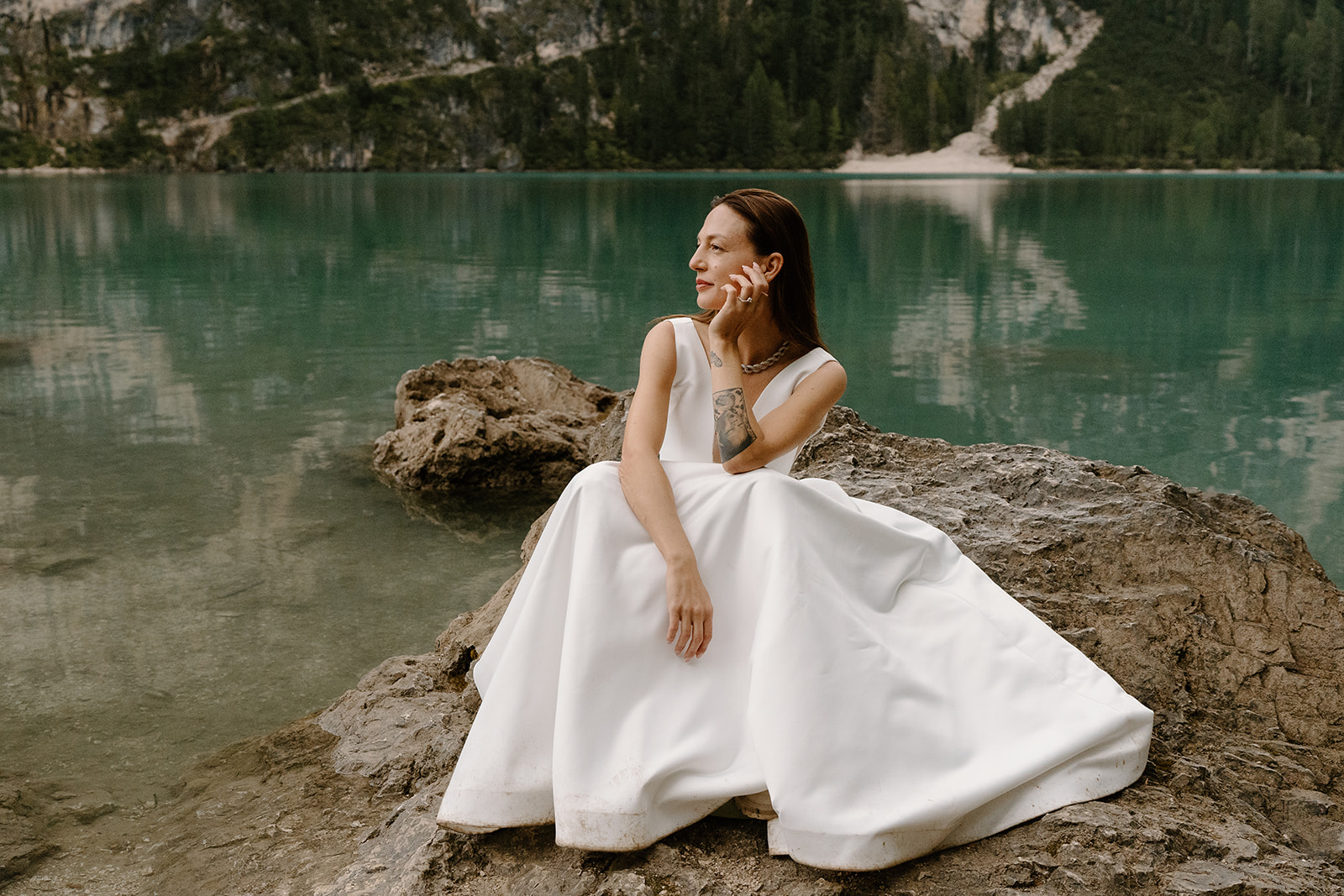 A couple poses for photos during their elopement at Lago di Braies in the Italian Dolomites.