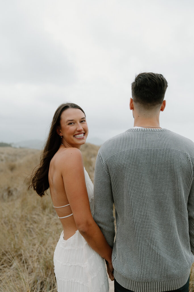 A couple poses for their Oregon Coast engagement photo session.