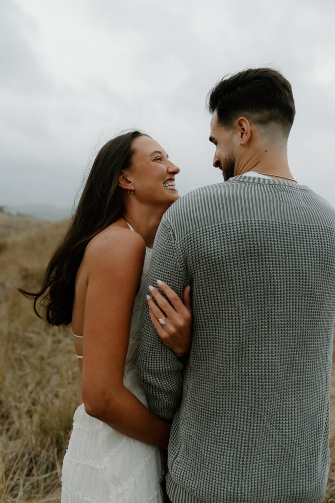 A couple poses for their Oregon Coast engagement photo session.