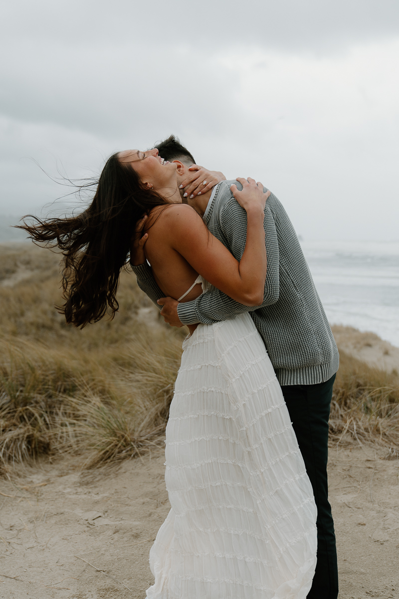 A couple poses for their Oregon Coast engagement photo session.
