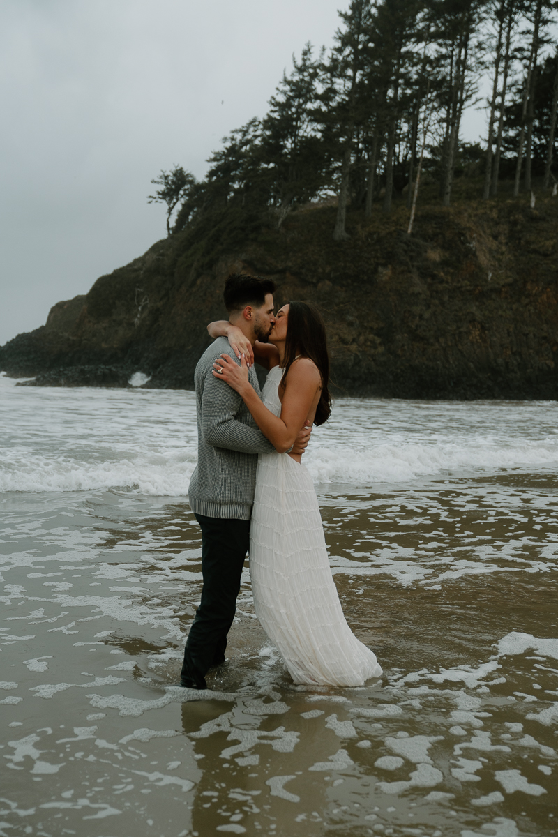 A couple plays on the beach for their Oregon Coast engagement photos.