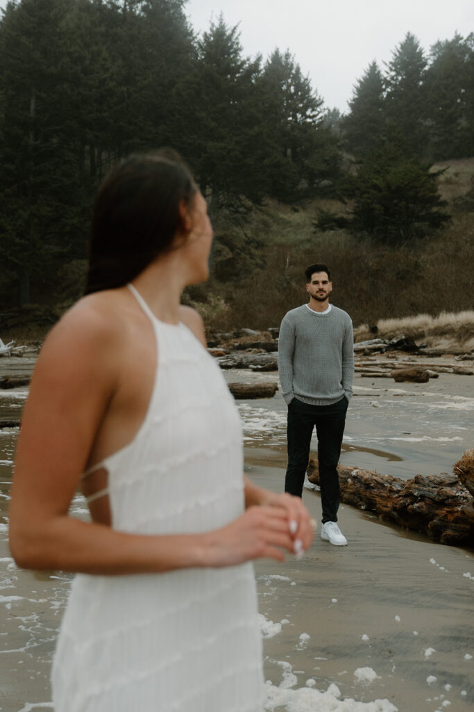 A couple plays on the beach for their Oregon Coast engagement photos.