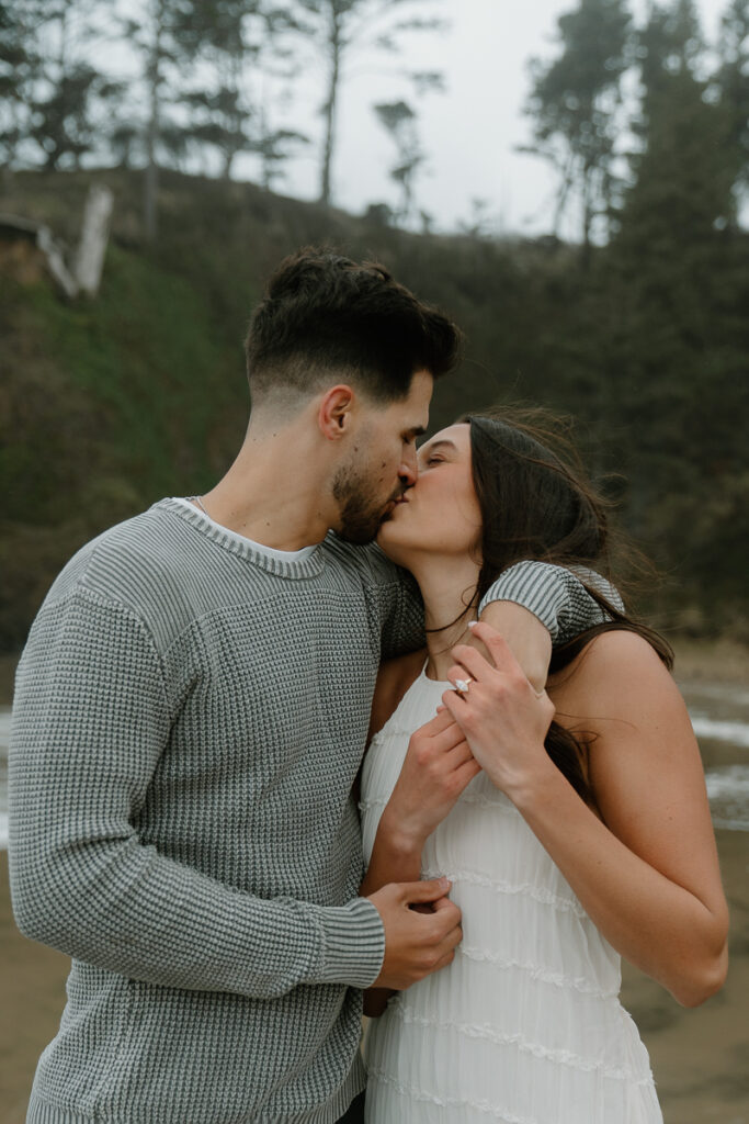 A couple plays on the beach for their Oregon Coast engagement photos.