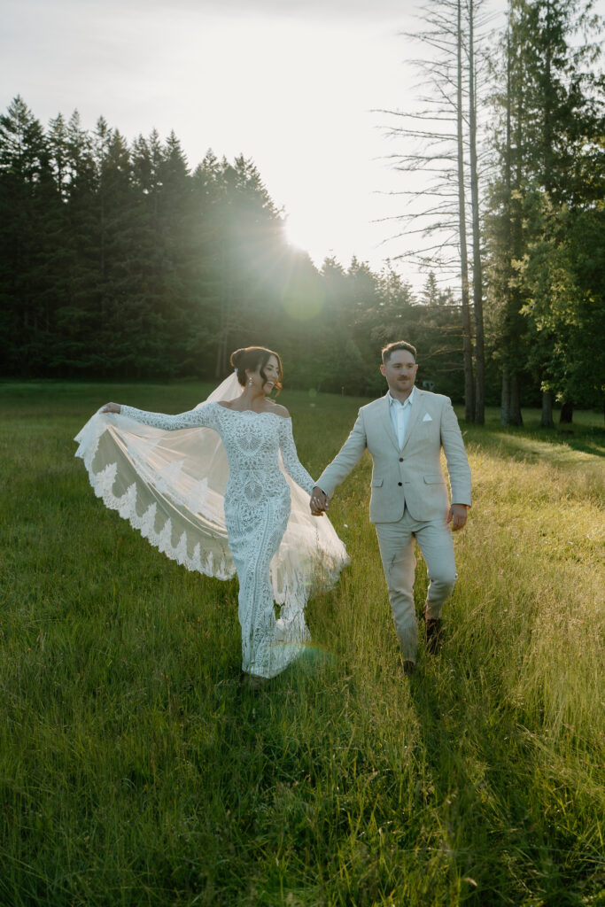 A couple laughs in a field together during their Wind Mountain Ranch wedding. 