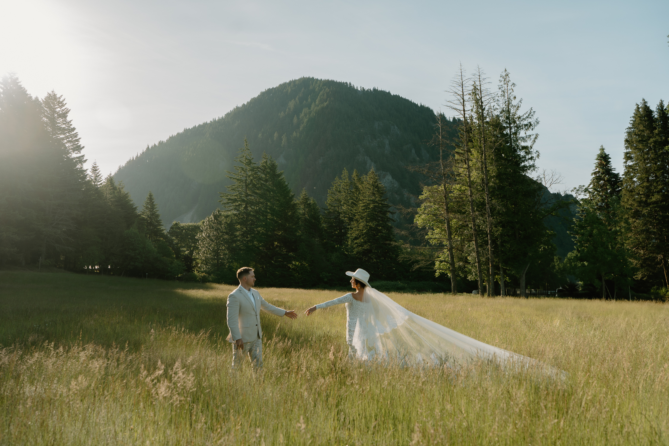 A couple reaches for each other during their wedding portraits at Wind Mountain Ranch