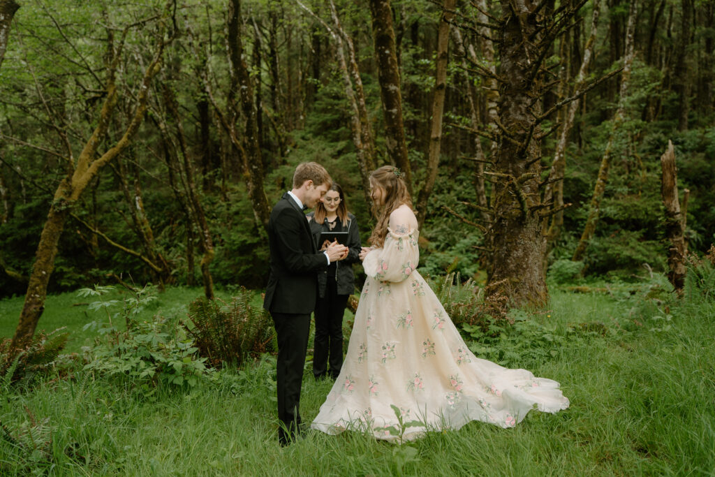 a couple exchanges vows in the trees during their cannon beach elopement