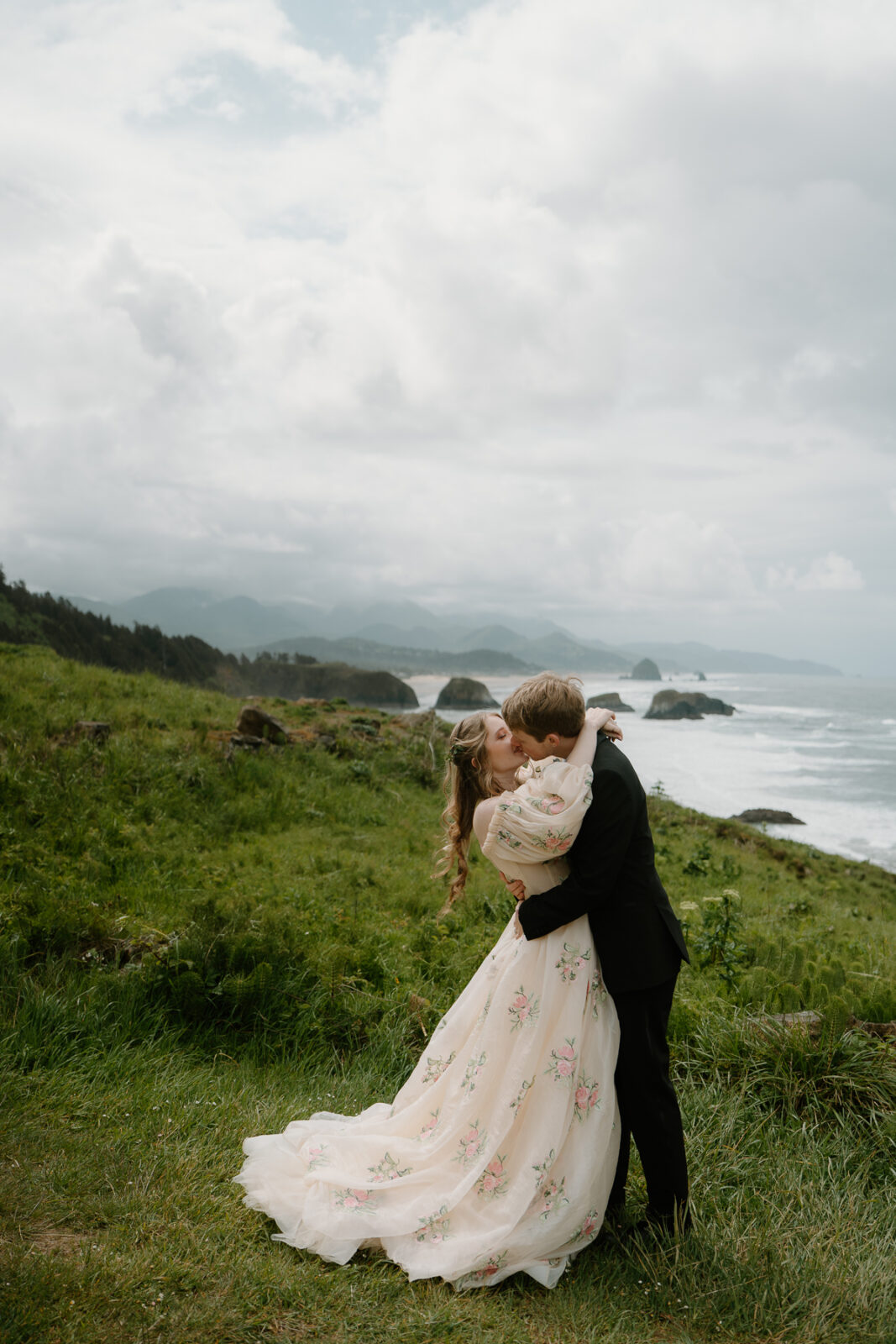 A couple kisses dramatically during their cannon beach elopement