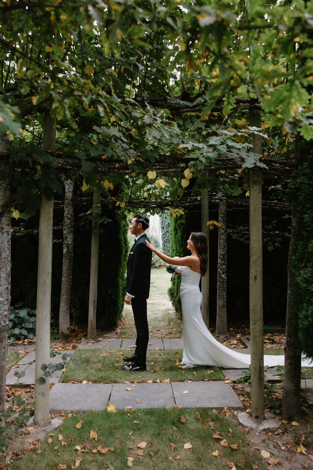 A couple in wedding attire snuggles together in a garden at their Briarwood Estate wedding.