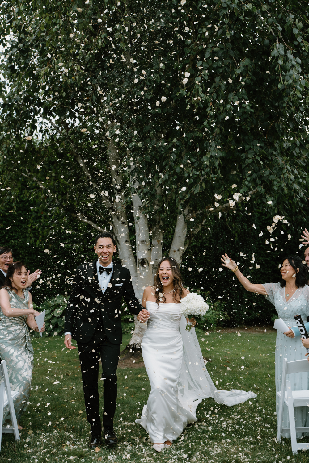 A couple celebrates after their first kiss at their Briarwood estate wedding.