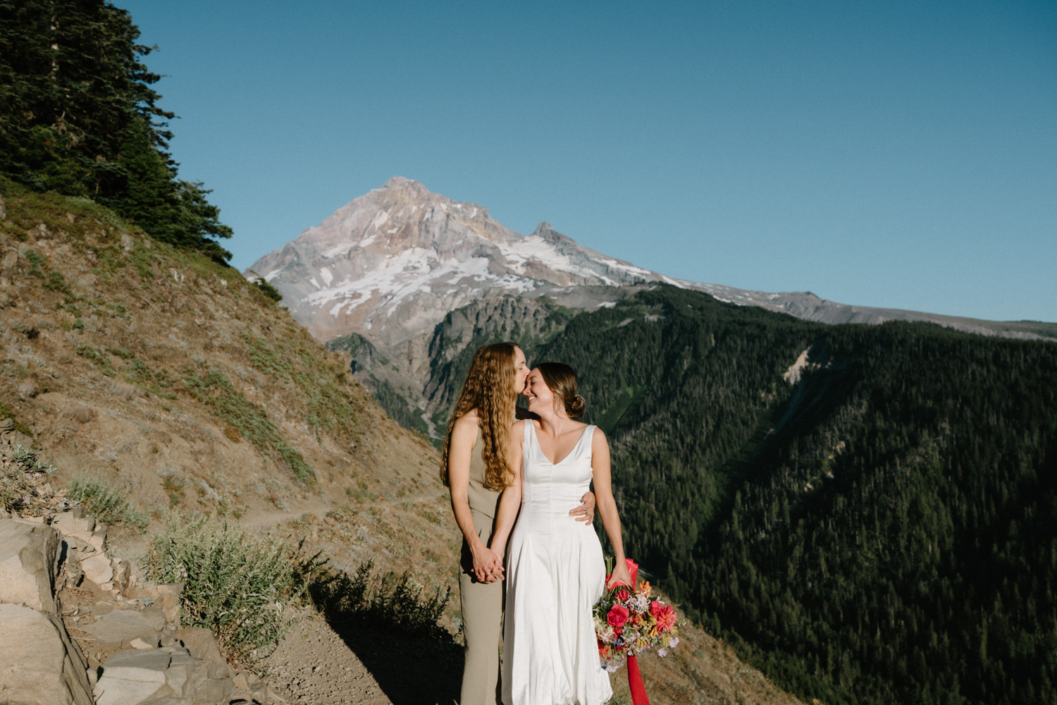 A couple stands in front of the mountain and embraces during their Mount Hood elopement