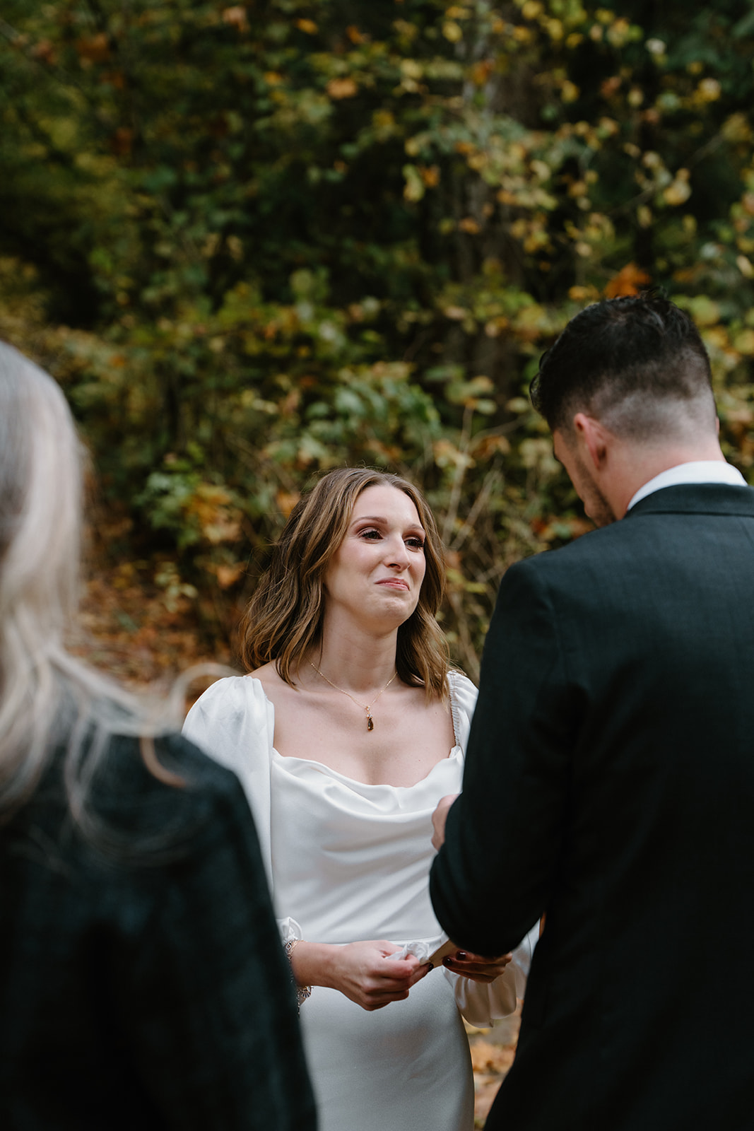 A bride's face is emotional as her groom reads his vows to her during their Latourell Falls elopement.