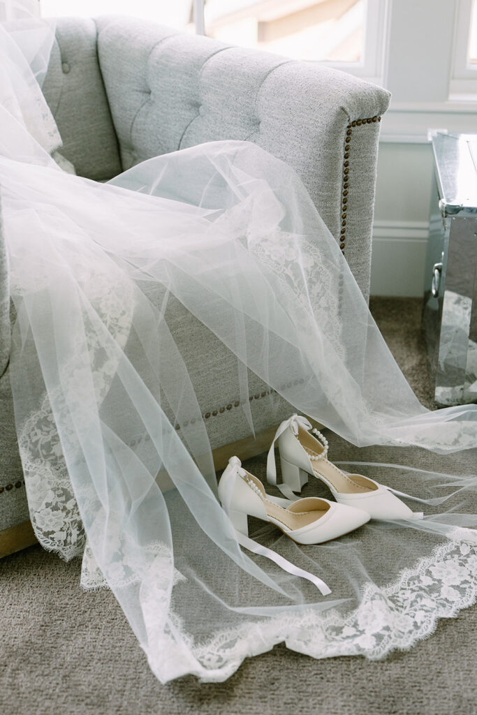 Bridal details at Roche Harbor Resort — cathedral veil and heels on a velvet chair before the ceremony.