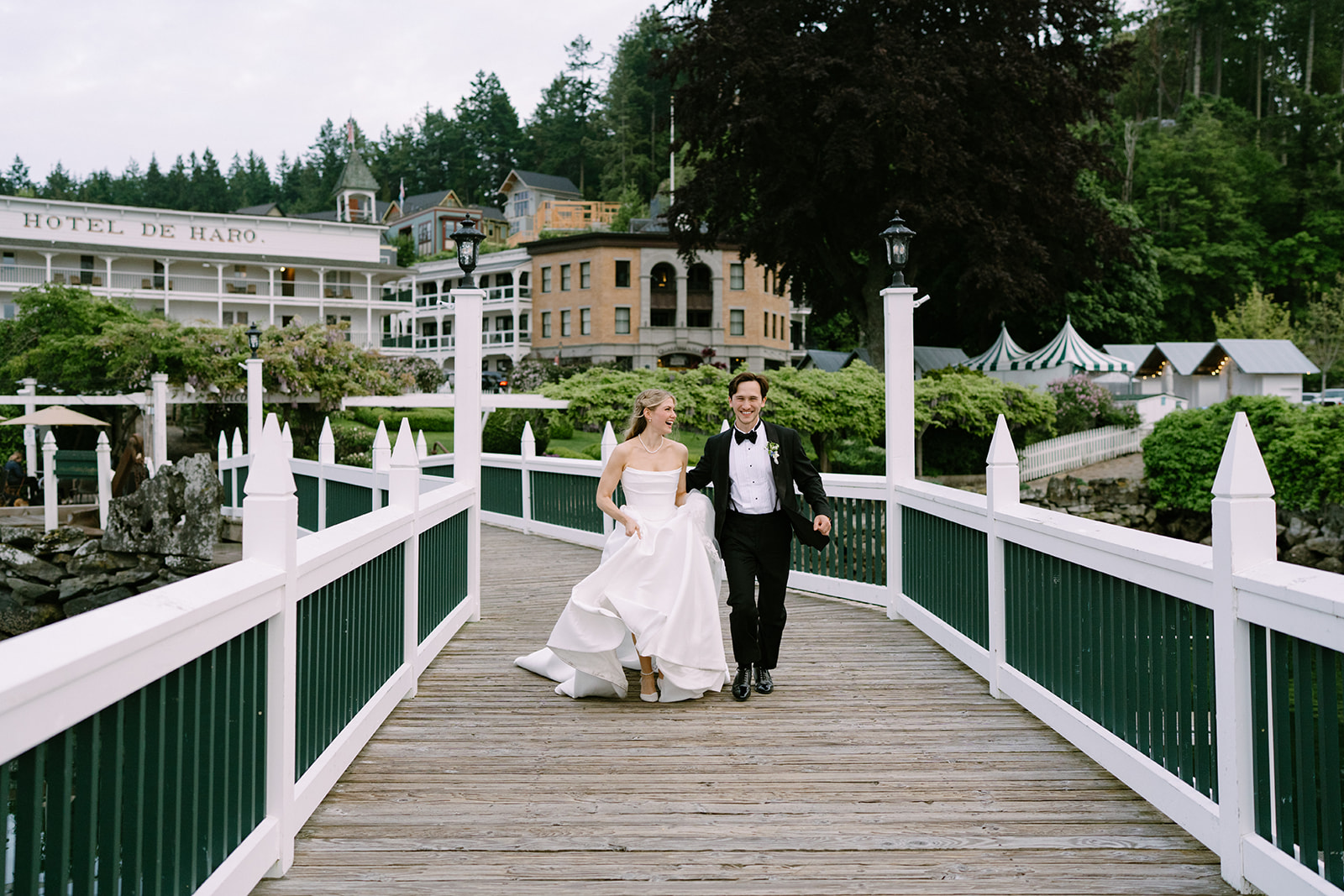 Amanda and Zach running hand in hand across the Roche Harbor Resort docks at sunset — San Juan Island wedding photography by Voyage + Vine.