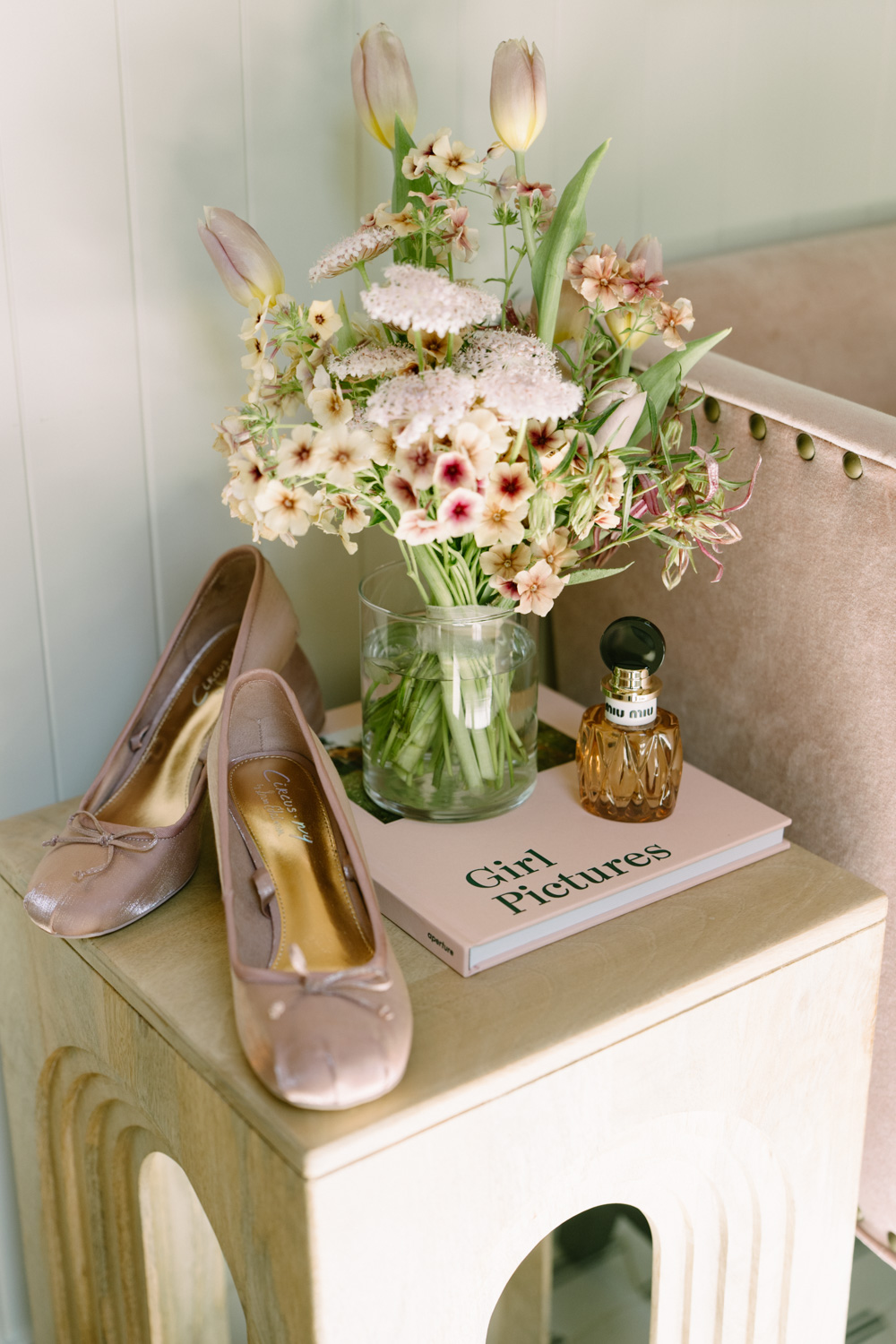 Feminine details with flowers, a pink book, shoes, set out at a Carly Estate wedding.