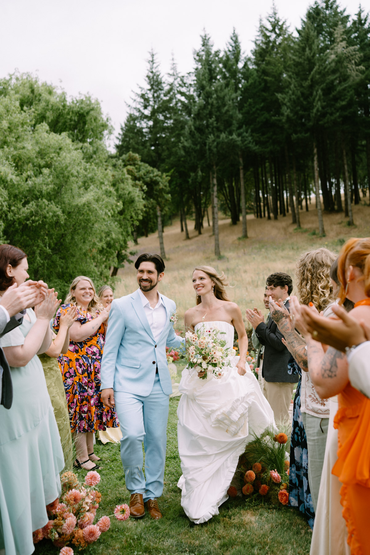 Guests clap as a couple walks back down the aisle during a wedding at Maysara Winery