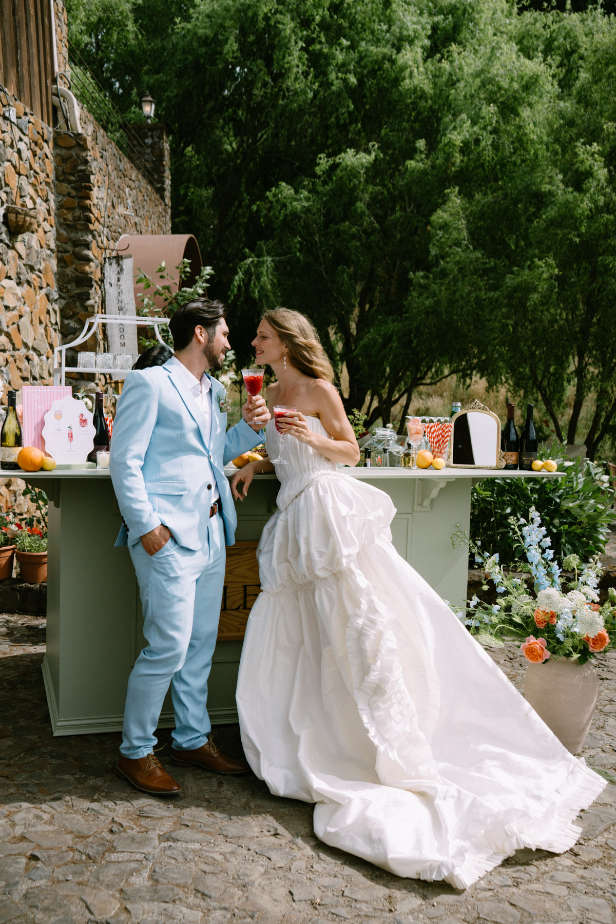 Bride and groom toast with colorful drinks at a wedding in Oregon's wine country