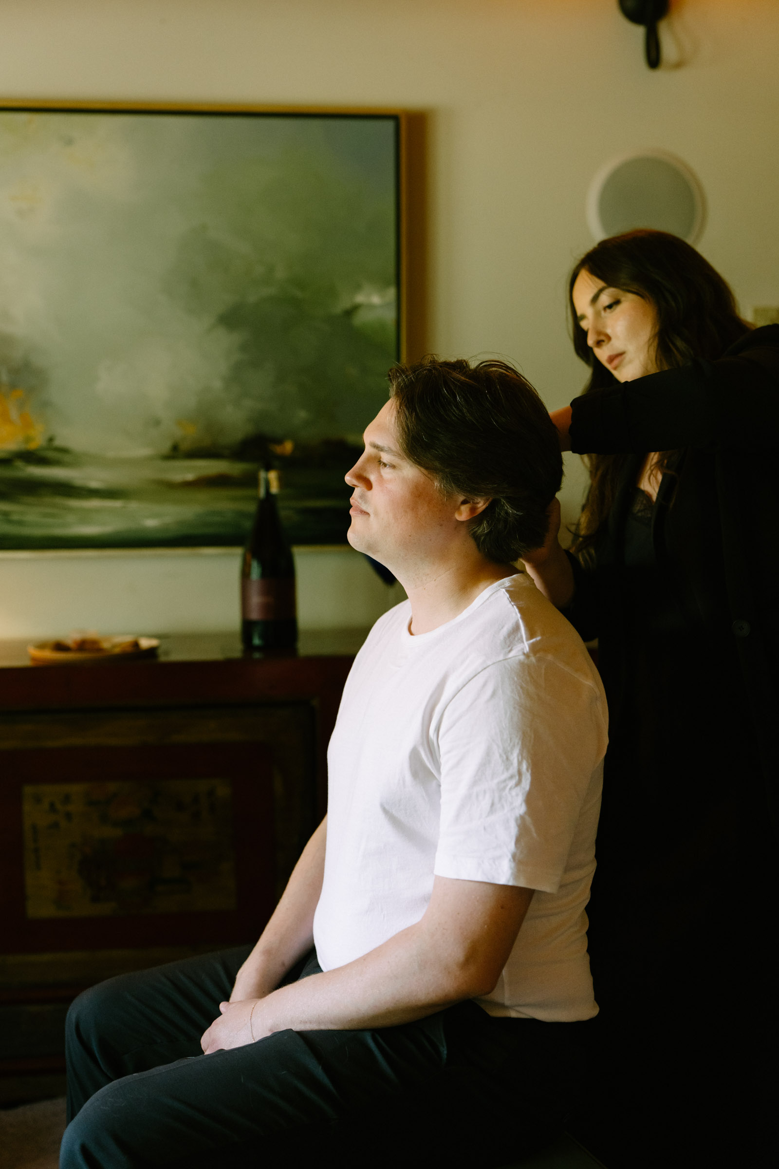Partner getting ready before the ceremony below a green landscape painting in the Kingston House interior