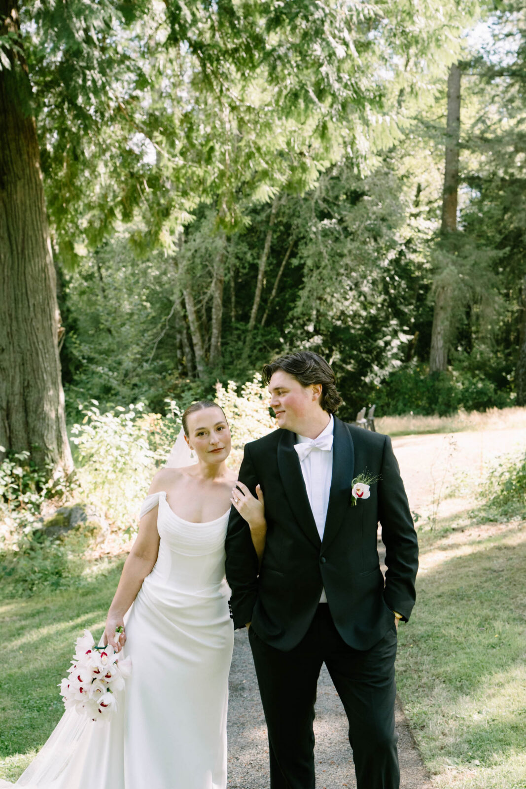 Couple walking through the garden at Anker Place after their first look, gown and dark suit