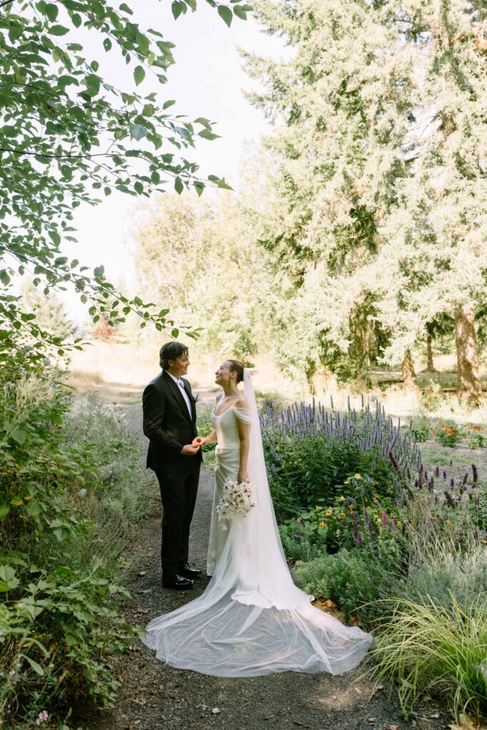 Couple in the Anker Place gardens surrounded by lavender and flower beds, long veil on the path