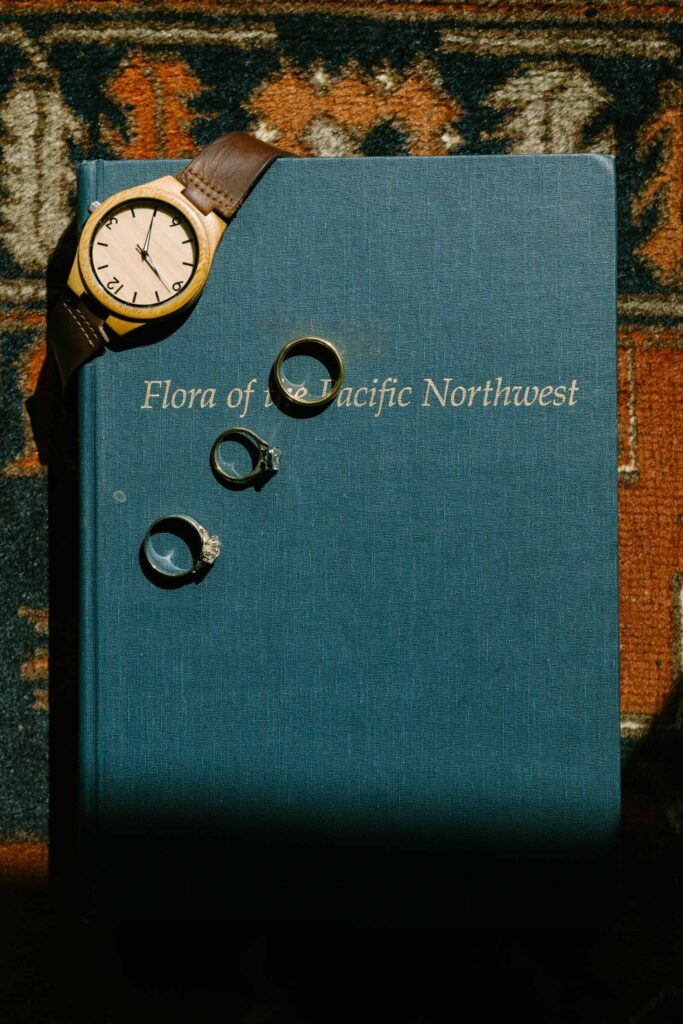 Wedding day details at an Anker Place wedding — gold rings and jewelry arranged on a book