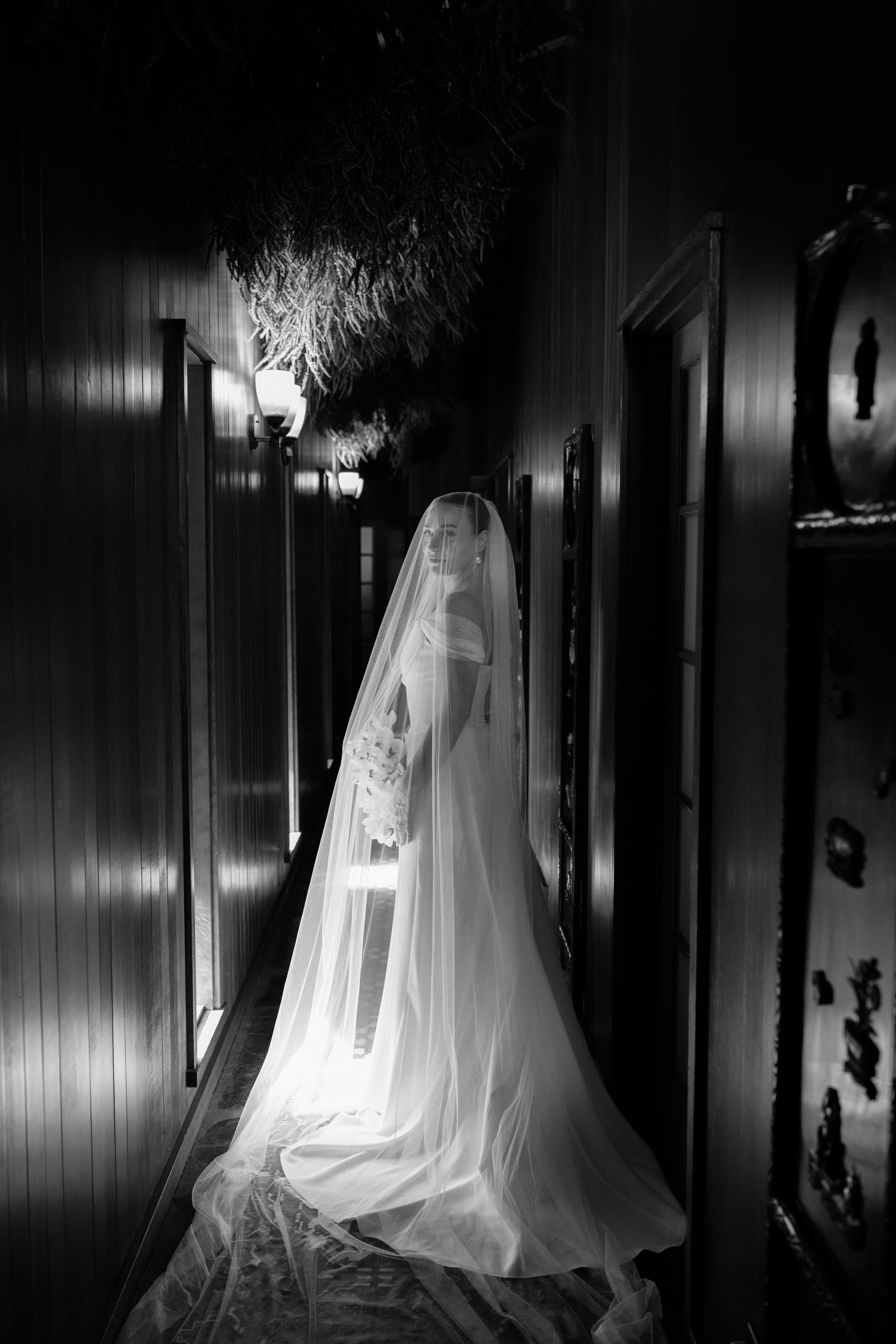 Partner in a gown and veil at the end of a wood-paneled corridor before the first look at Anker Place