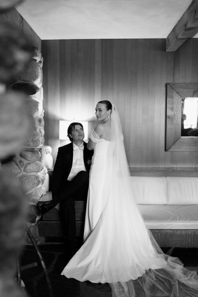 Wedding portrait inside Anker Place, one partner seated and the other standing in a gown with a long veil