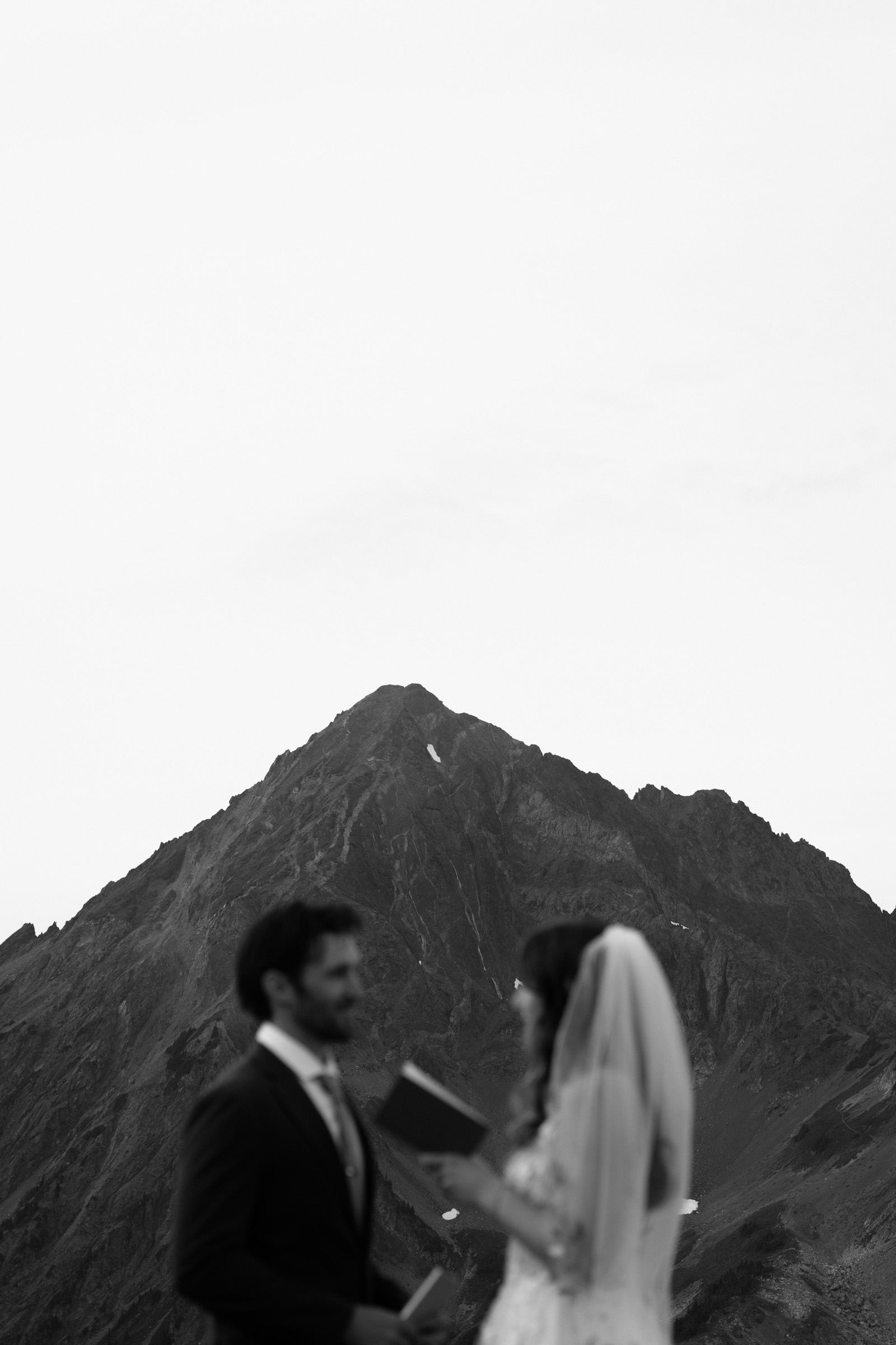 A black and white photo of a couple exchanging vows during their North Cascades elopement. 